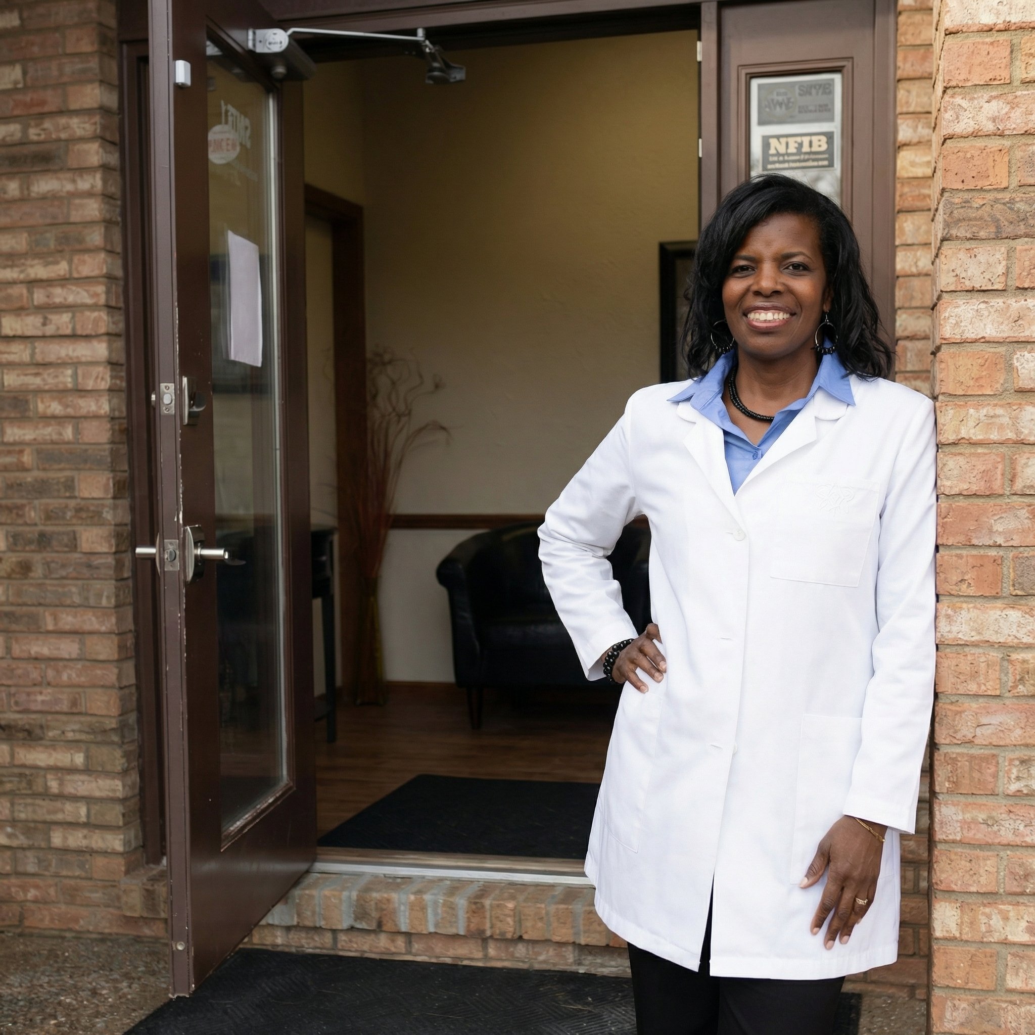 Dr. Mukaia at clinic entrance ready to welcome new patients